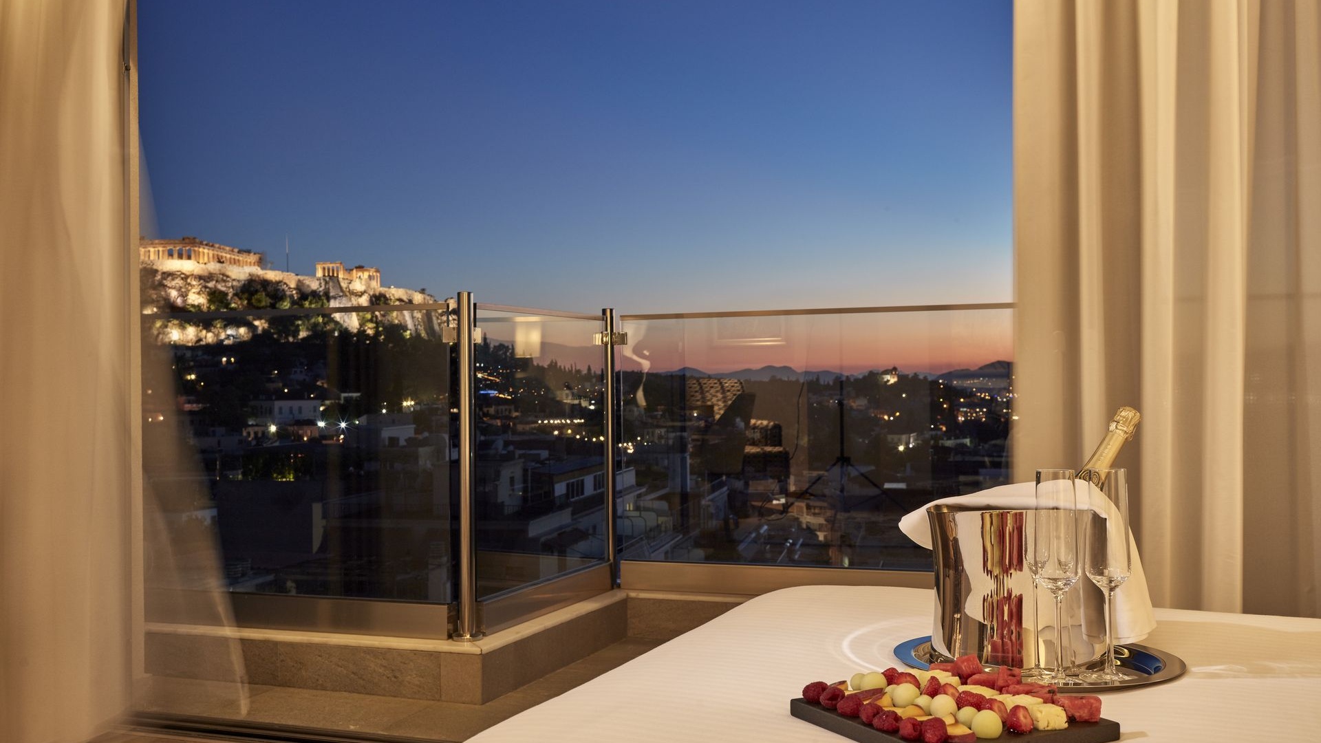 Evening view of the Acropolis from the Acropolis Suite at Electra Metropolis hotel in Athens, for your most romantic getaways in Greece's capital.