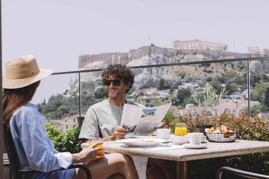 Pareja disfrutando del desayuno en Metropolis Roofgarden durante sus escapadas románticas en Atenas, Grecia.