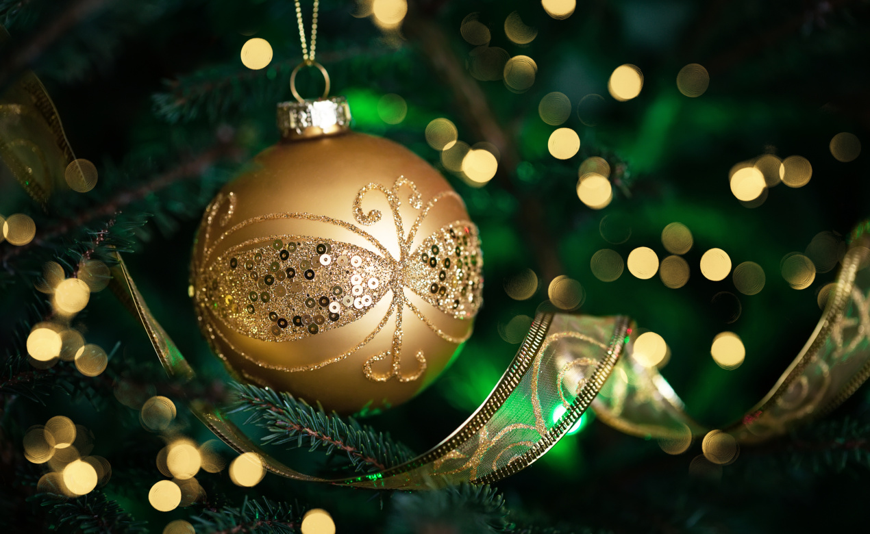 Close Up Of Golden Ball On Christmas Tree. Christmas Fir Tree Wi