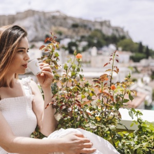 Lady enjoying her coffee on the rooftop of Electra Metropolis, one of the most popular outdoor activities in Athens for locals