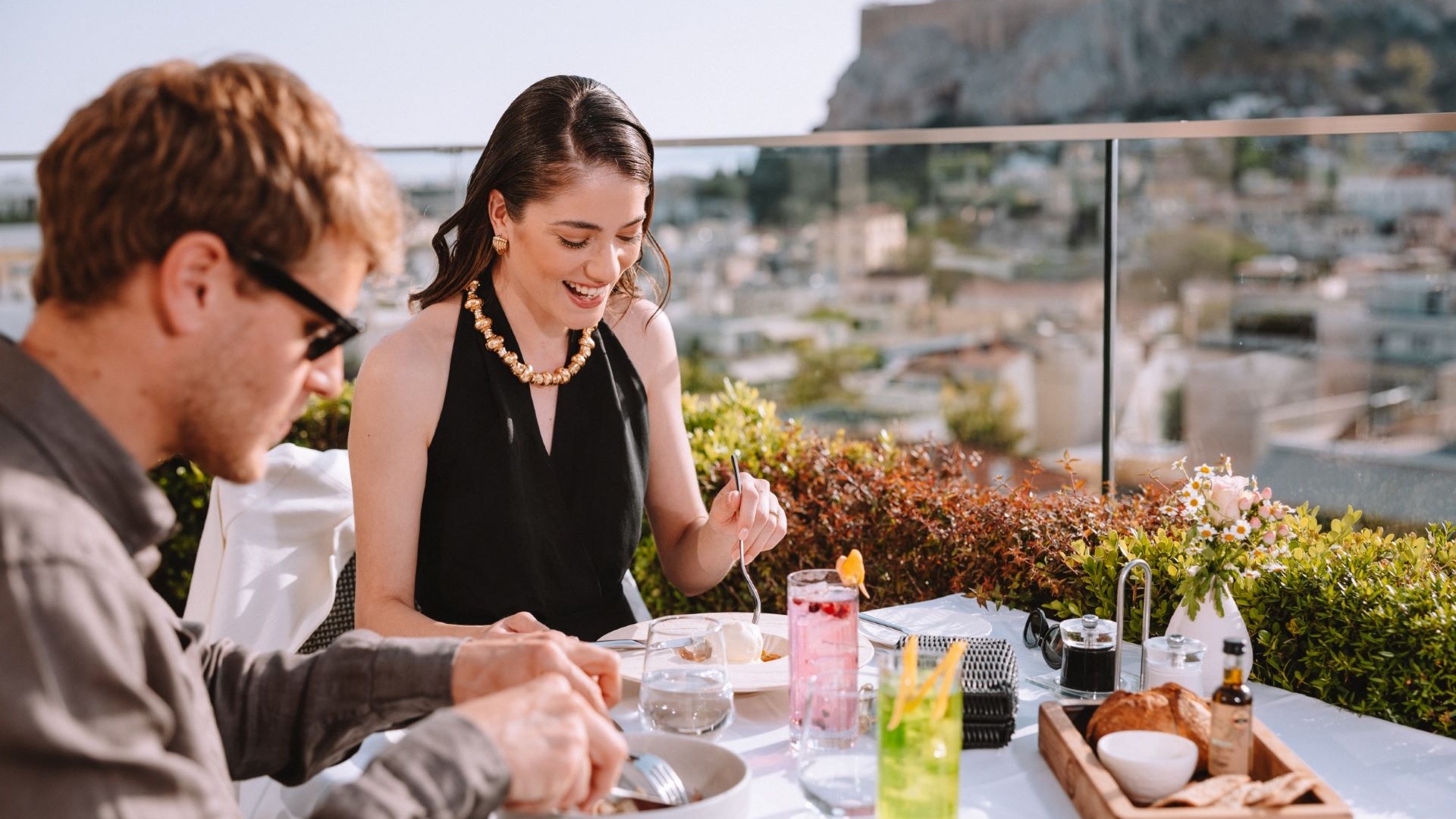 Couple enjoying a meal and refreshments on the rooftop restaurant of Electra Hotels during their Athens itinerary for 2 days. 
