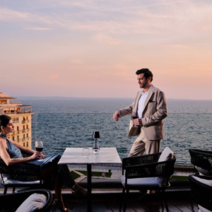 A couple enjoying wine at Orizontes Roof Garden overlooking Aristotelous Square and the Thermaic Gulf, an ideal for foodie travel in Thessaloniki.